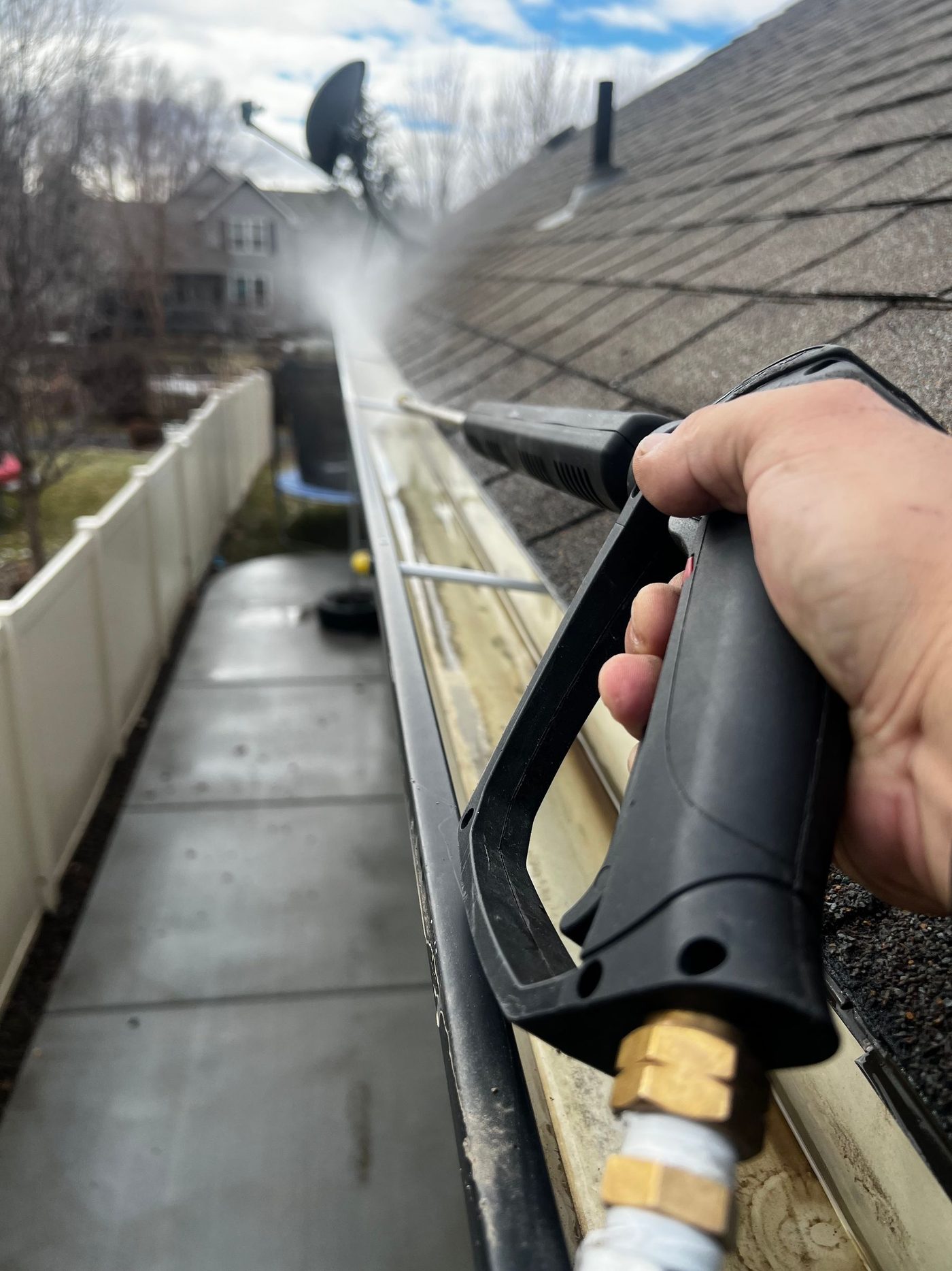 Professional cleaning out a residential rain gutter
