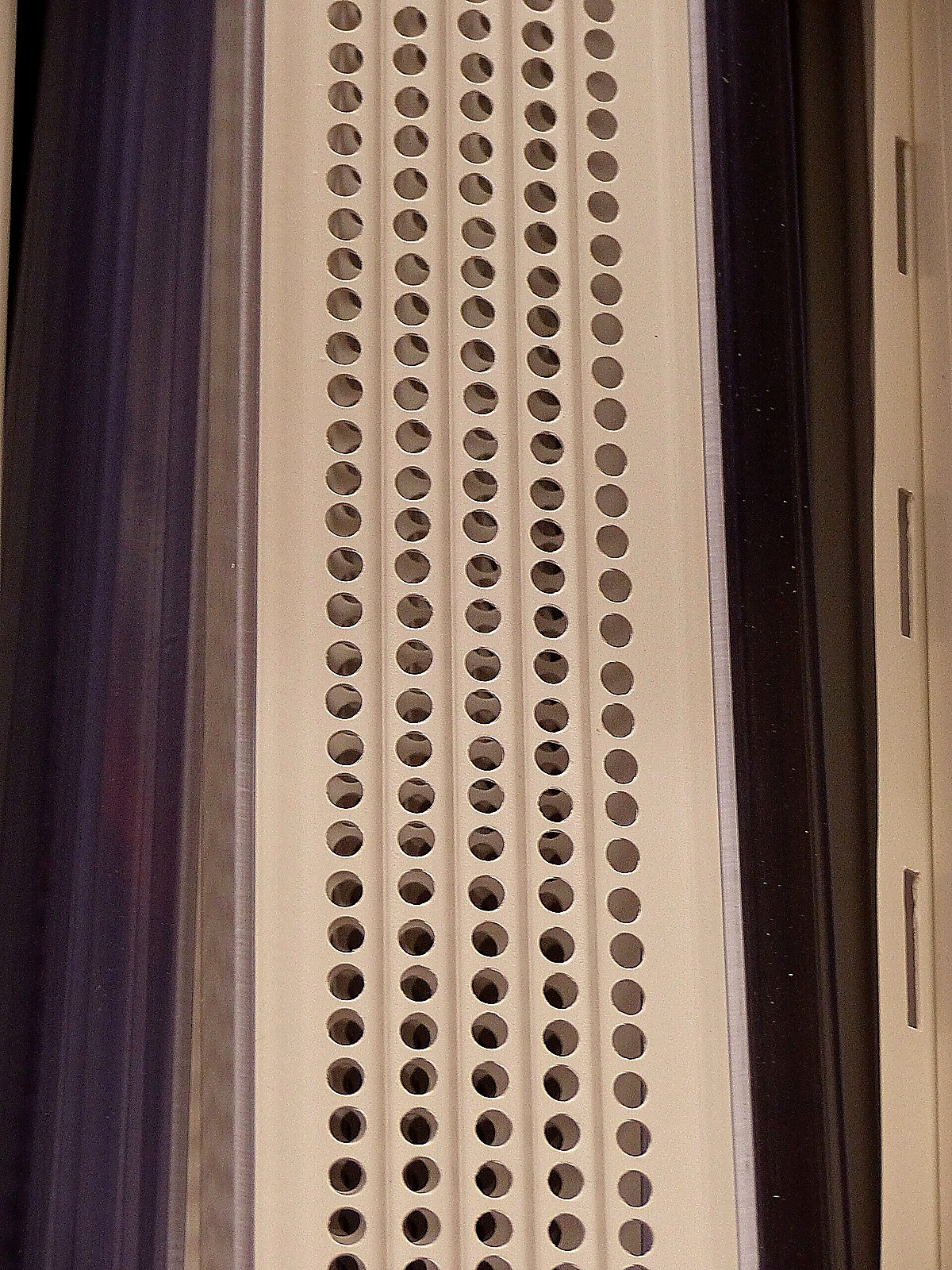 Perforated leaf guard fitted along a gutter run