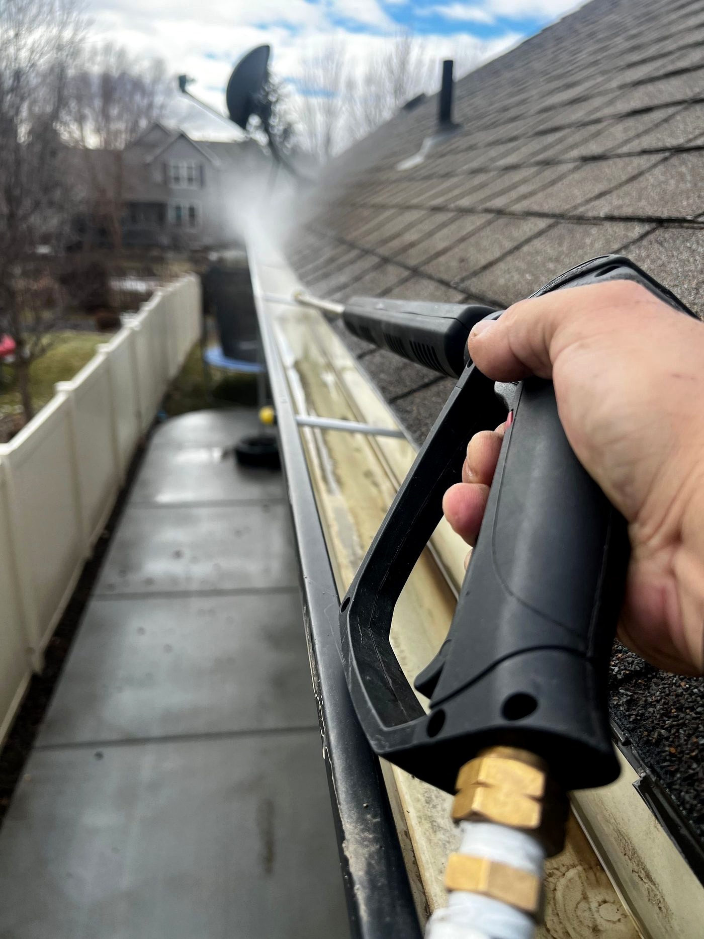 Professional clearing leaves and debris from a rain gutter
